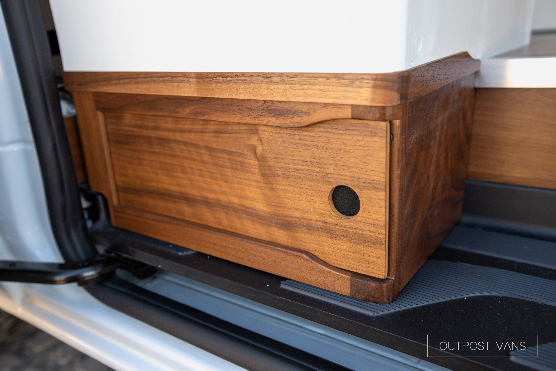 A wooden box is sitting in the back of a van.