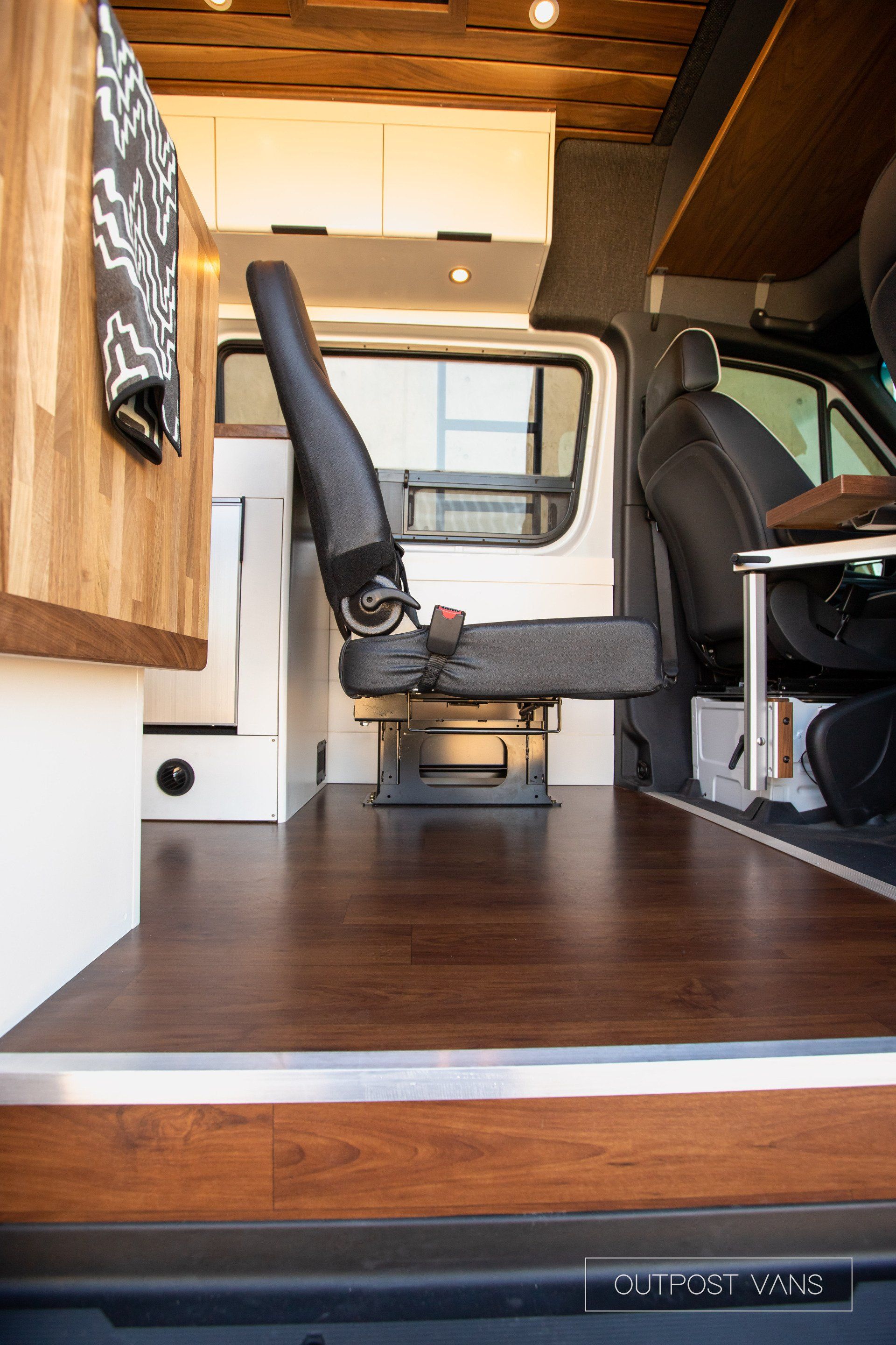 A van with a wooden floor and a seat in the back.