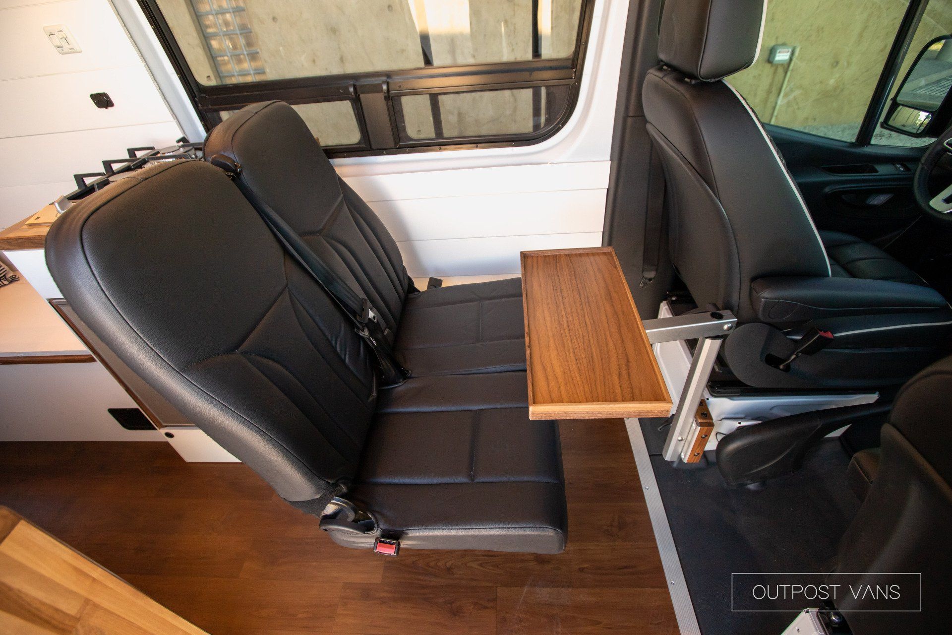 The back seat of a van has a wooden table attached to it.