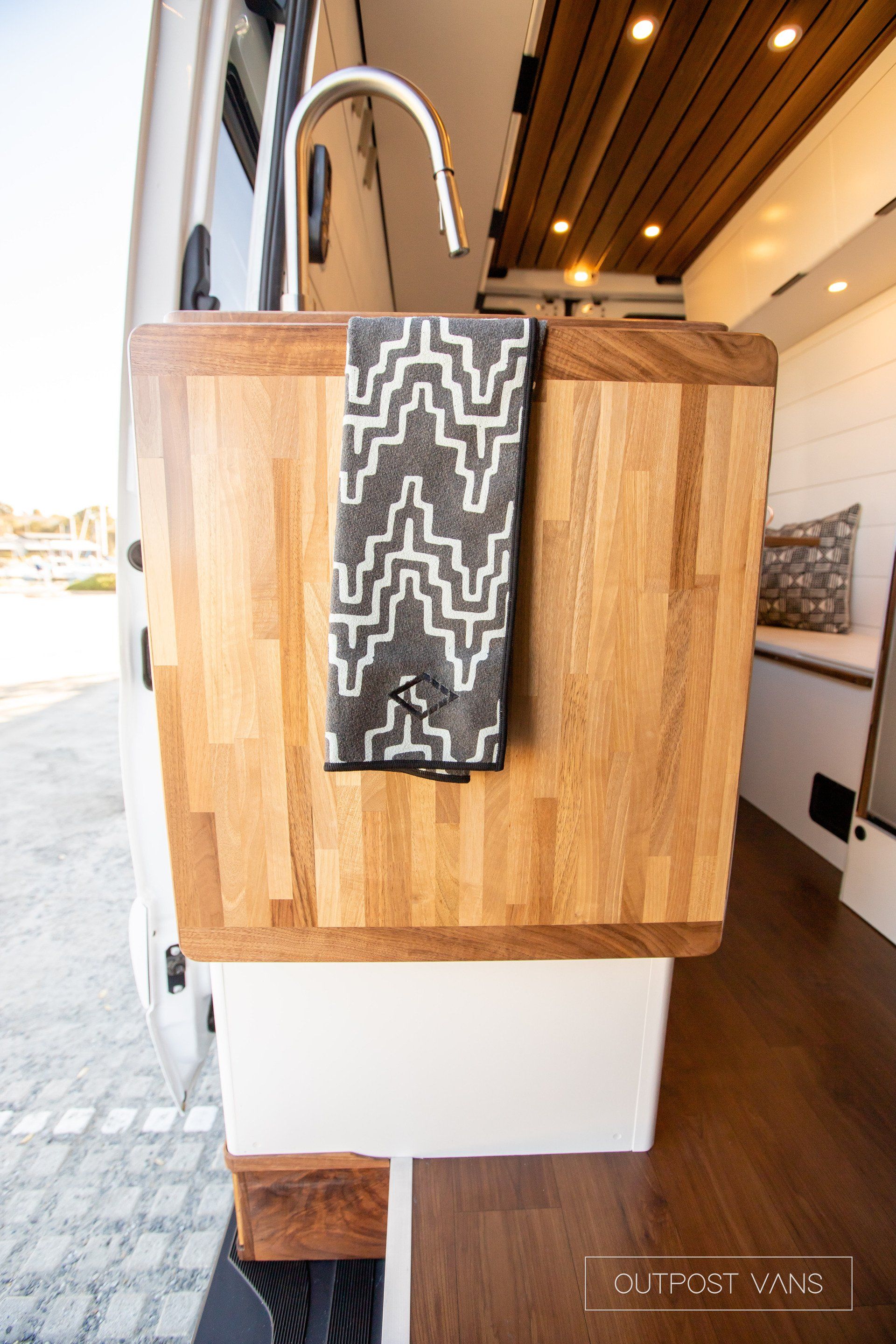 A towel is hanging from a wooden counter in a van.