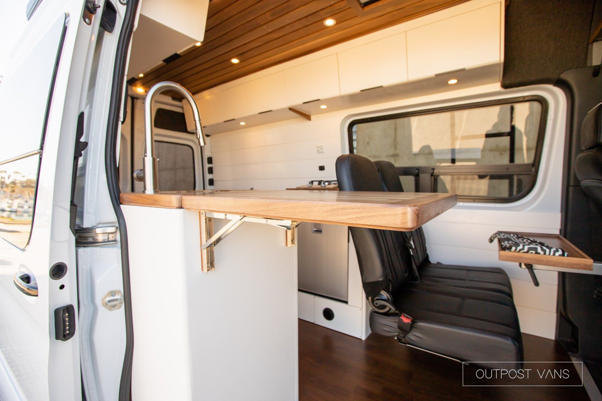 The inside of a van with a table and chairs.