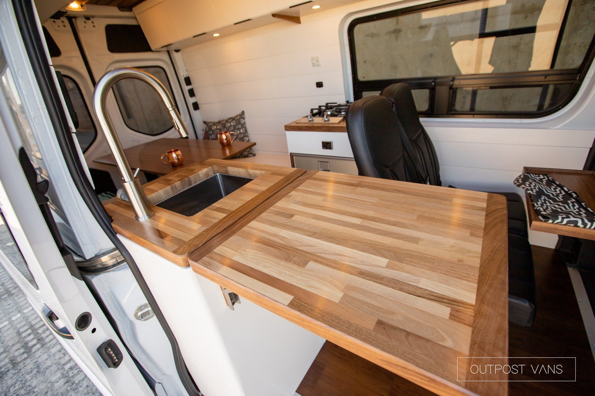 A van with a wooden counter top and a sink.