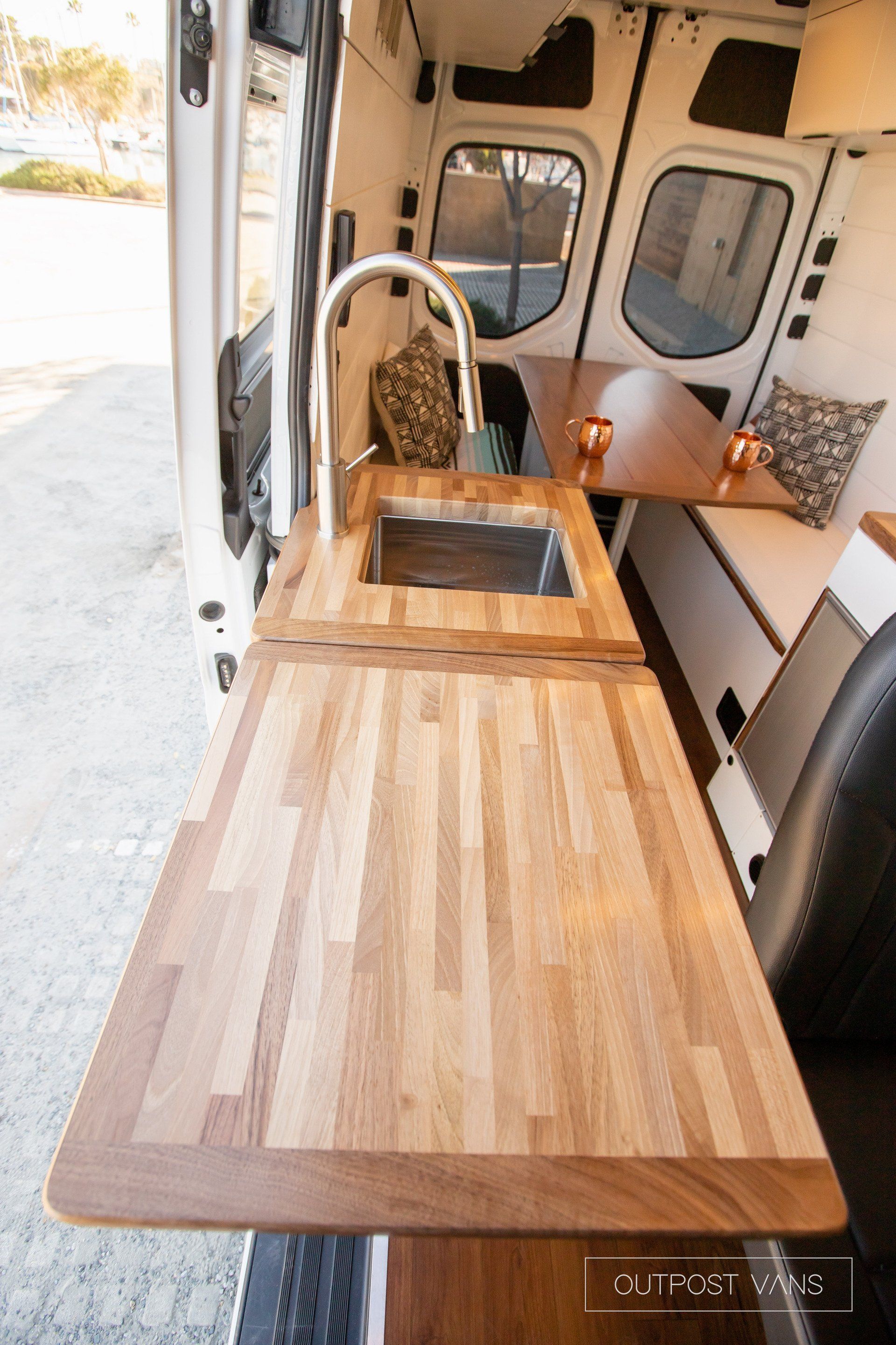 A van with a wooden counter top and a sink.