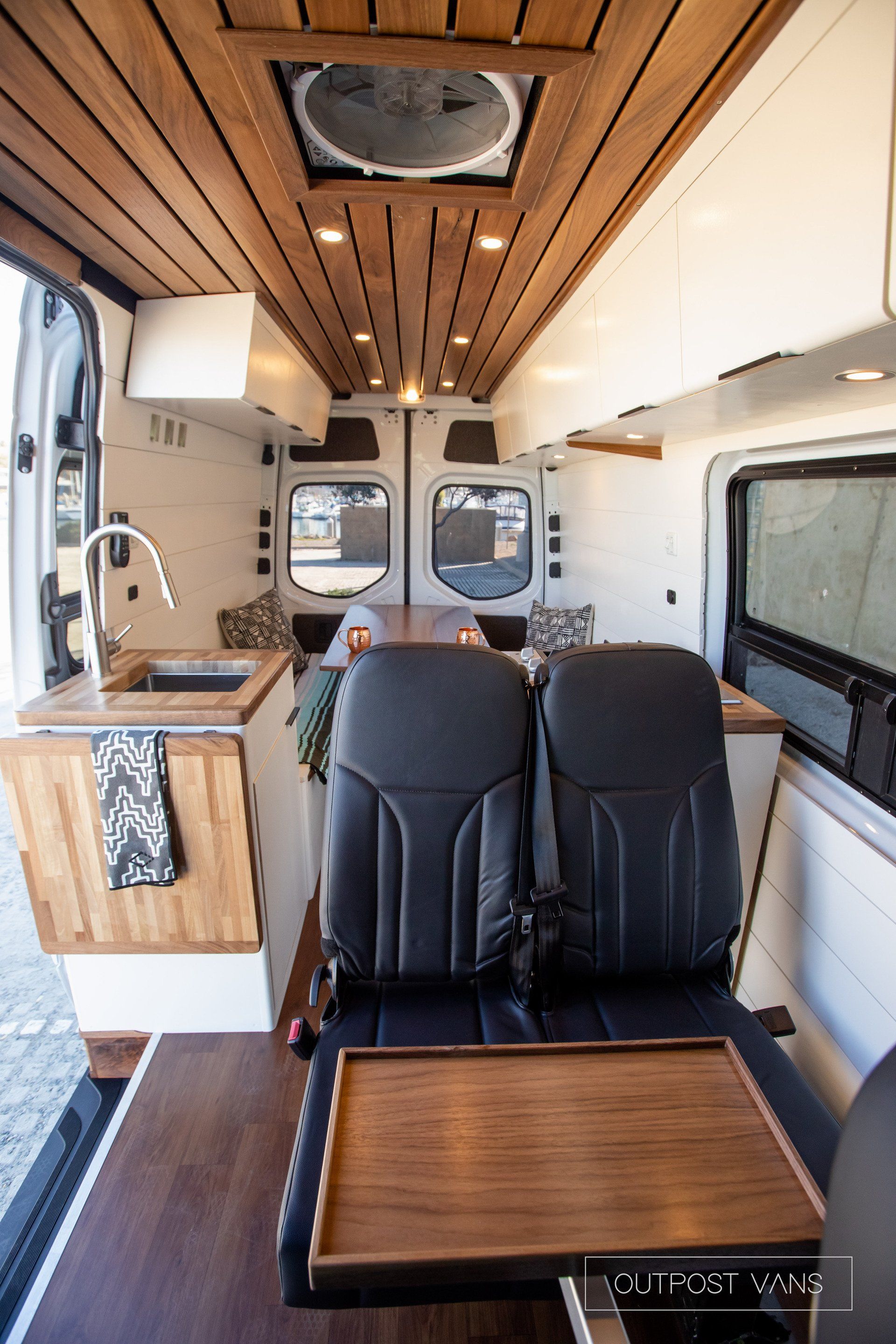 The inside of a van with a table and chairs.