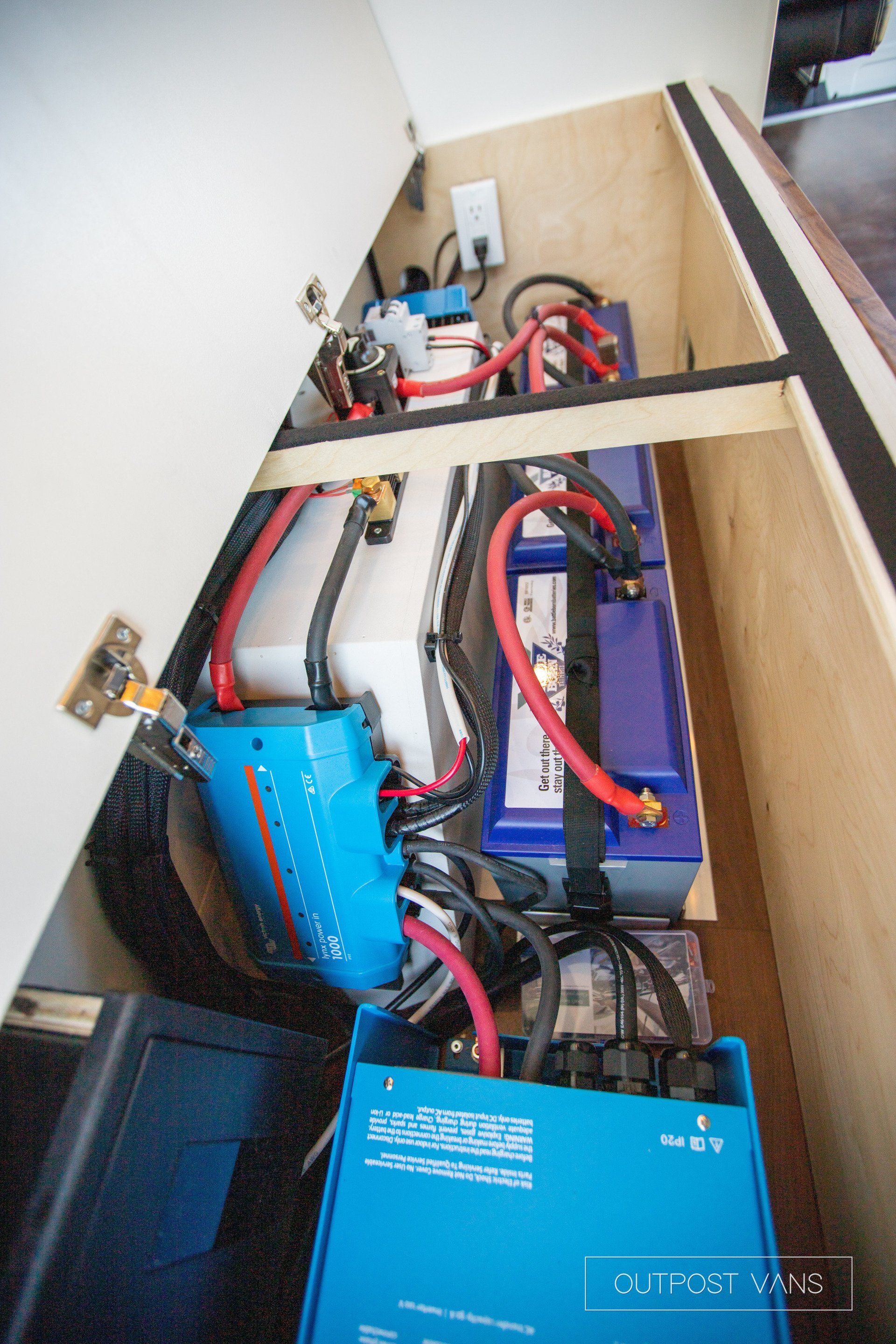 A bunch of batteries are sitting inside of a cabinet.