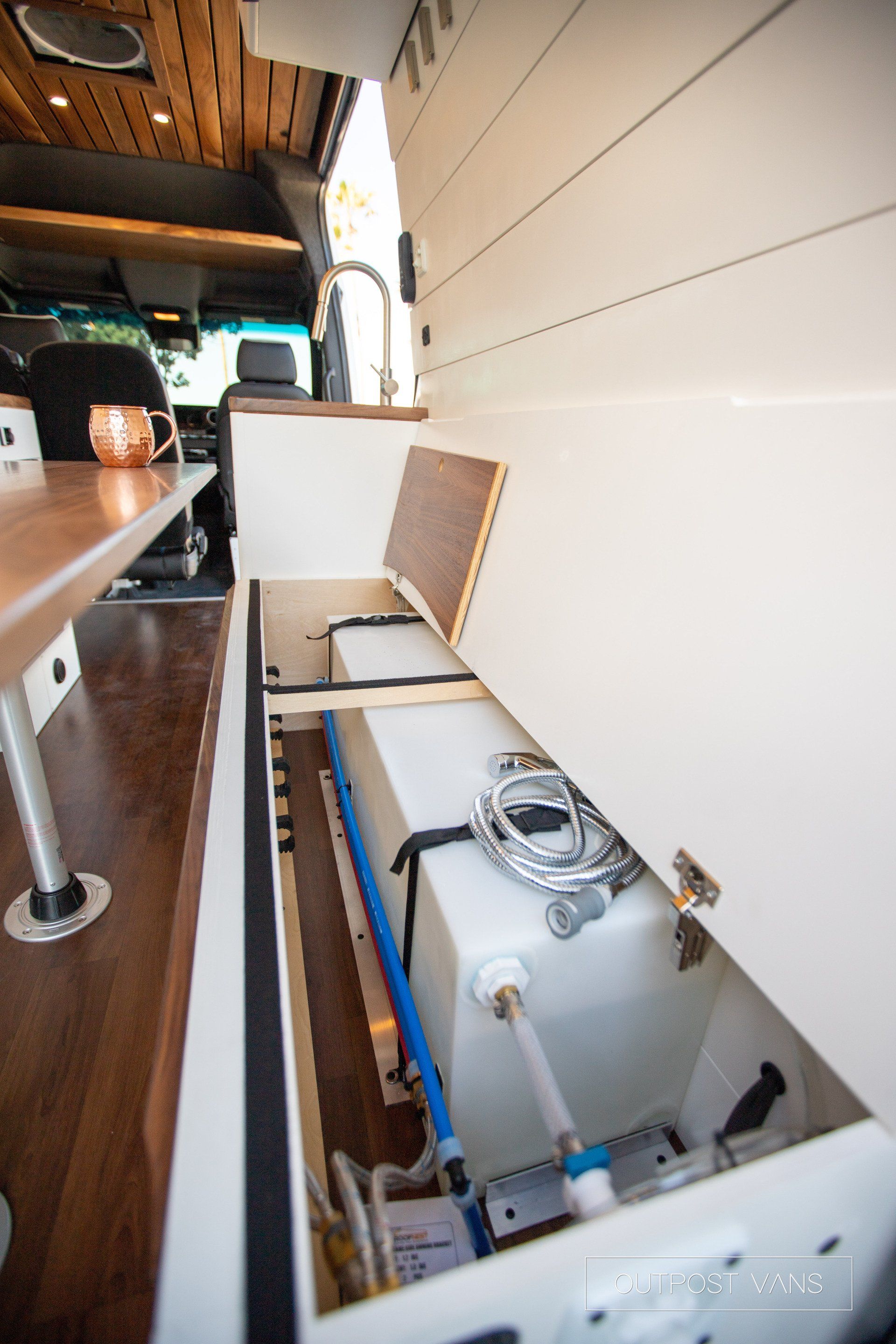 There is a water tank in the back of a van.