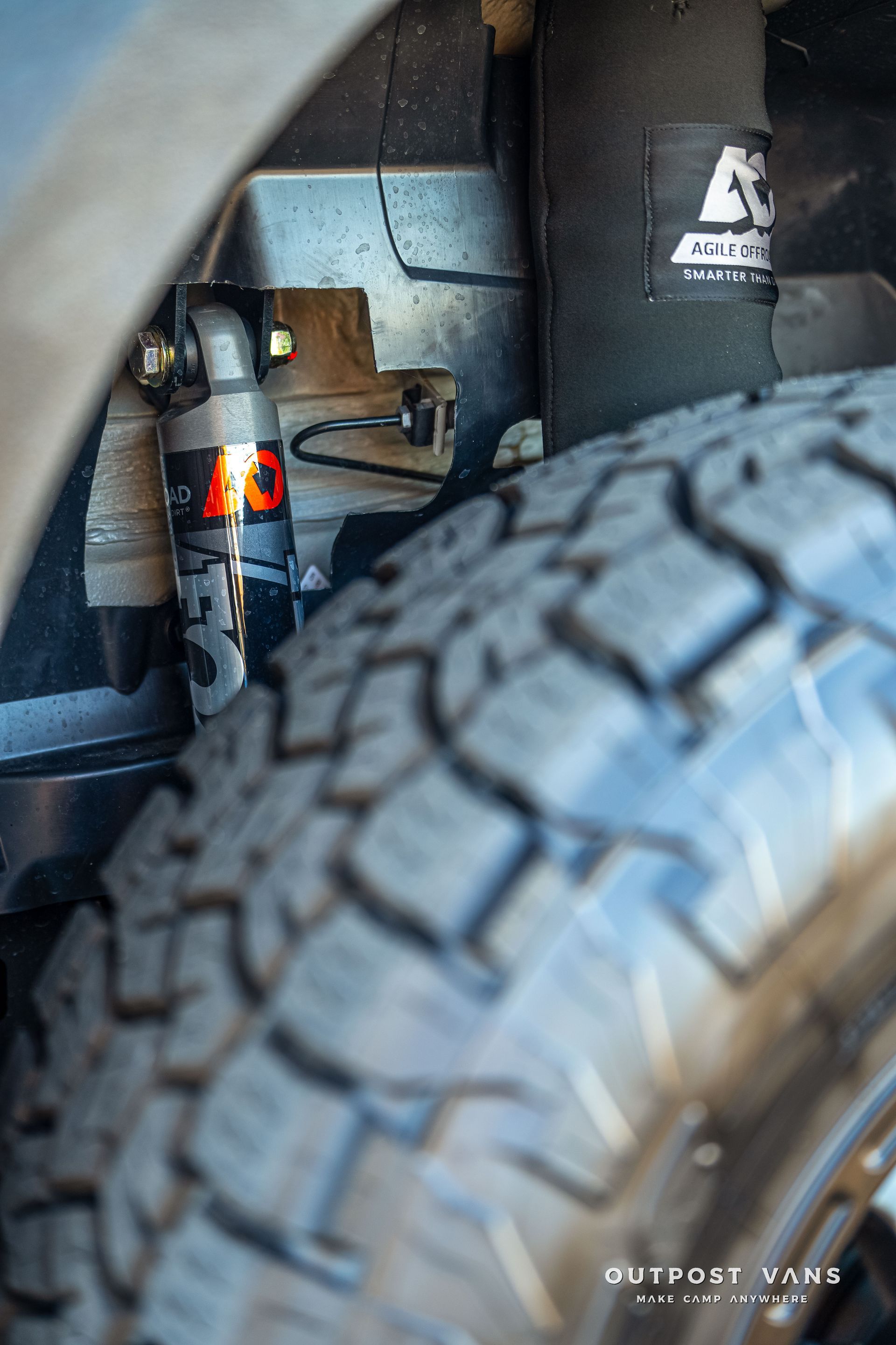 Close-up of a vehicle's tire and suspension system with a Fox shock absorber visible.