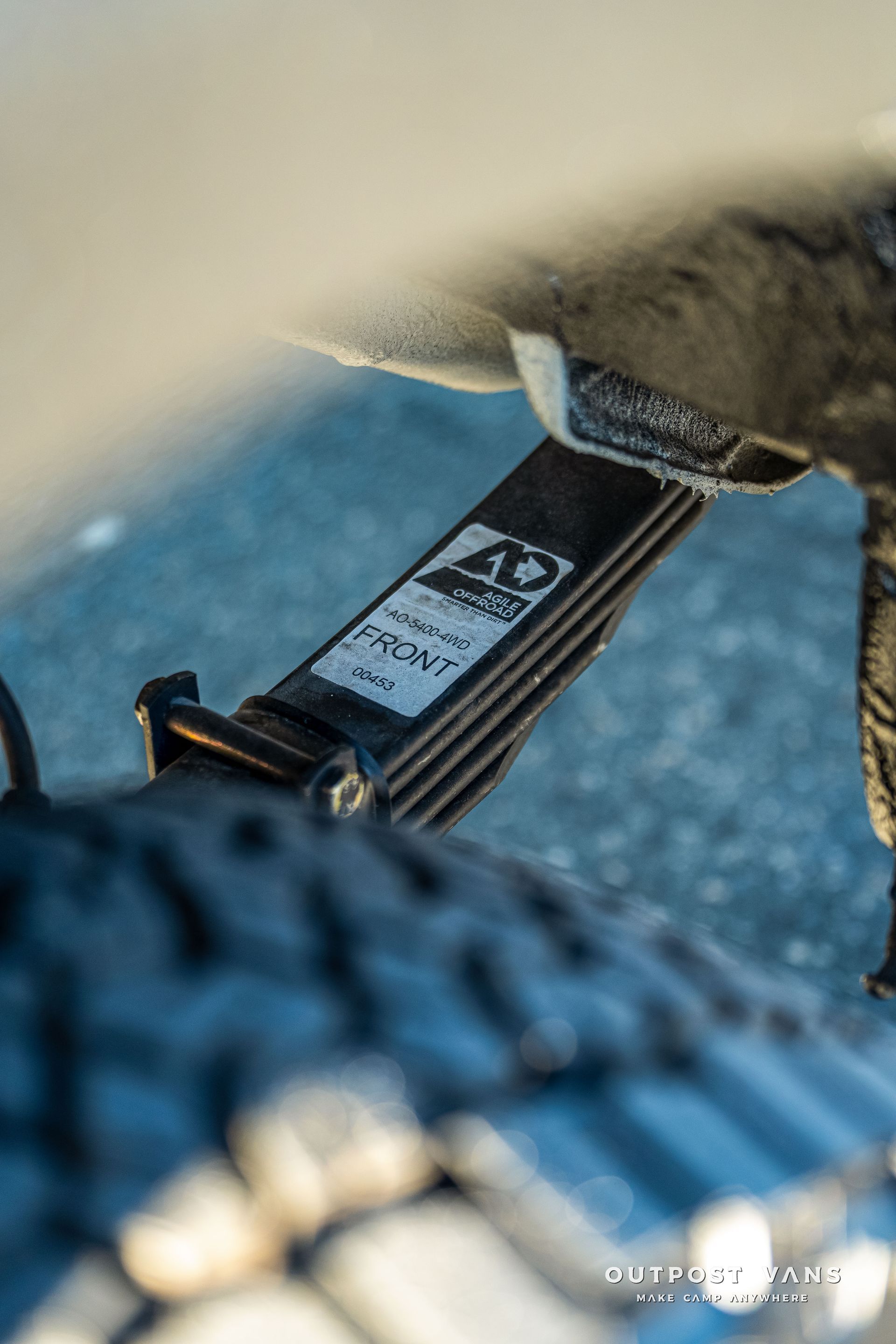 Black leaf spring on a vehicle, labeled 