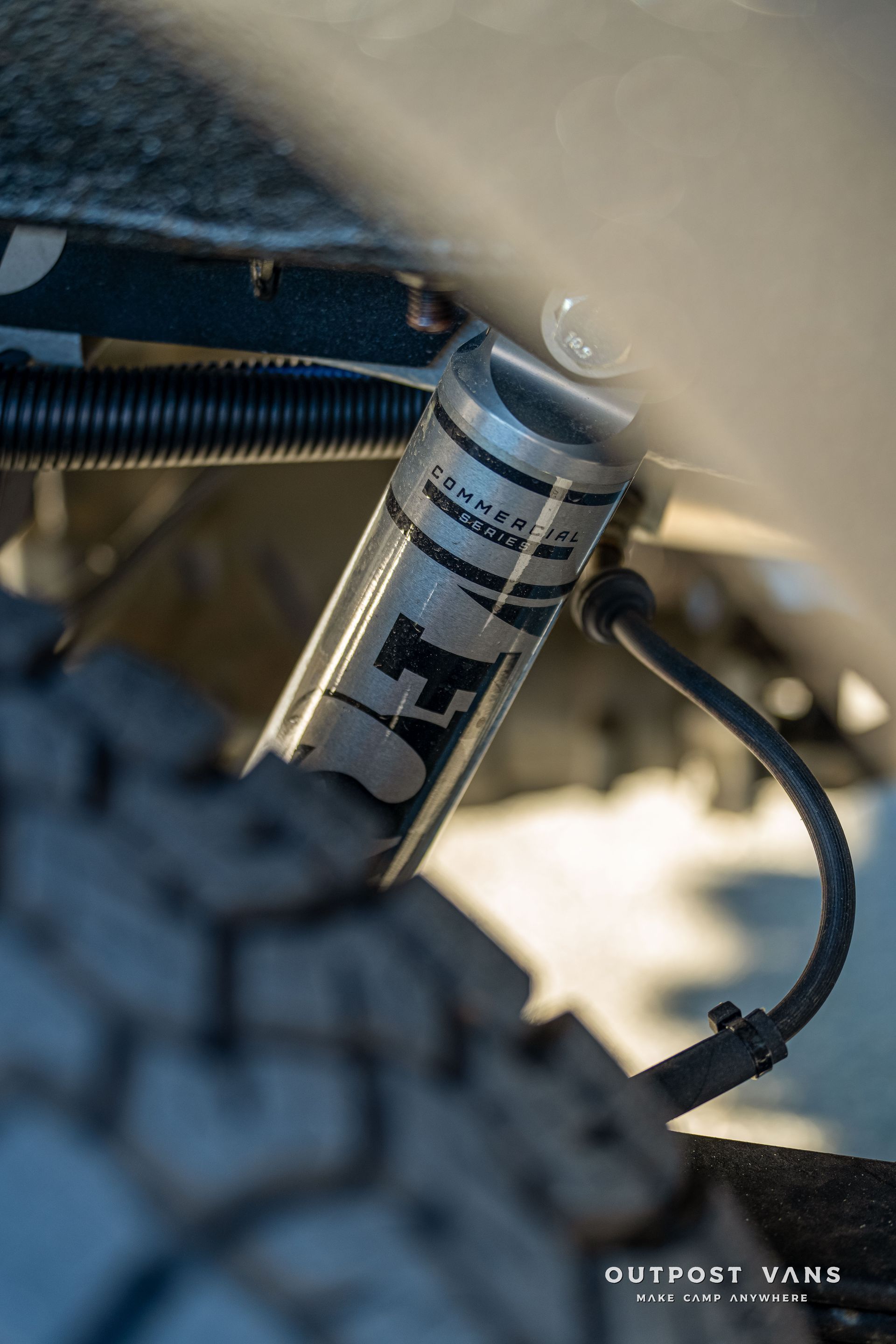 Silver Fox shock absorber on a vehicle, close-up with tire in the foreground.