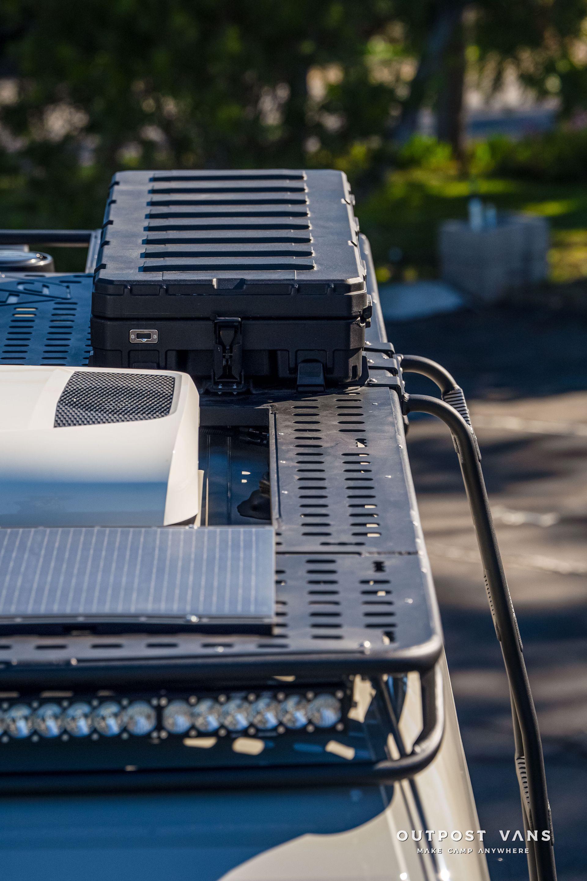 Truck roof with mounted solar panel, storage box, and LED light bar.