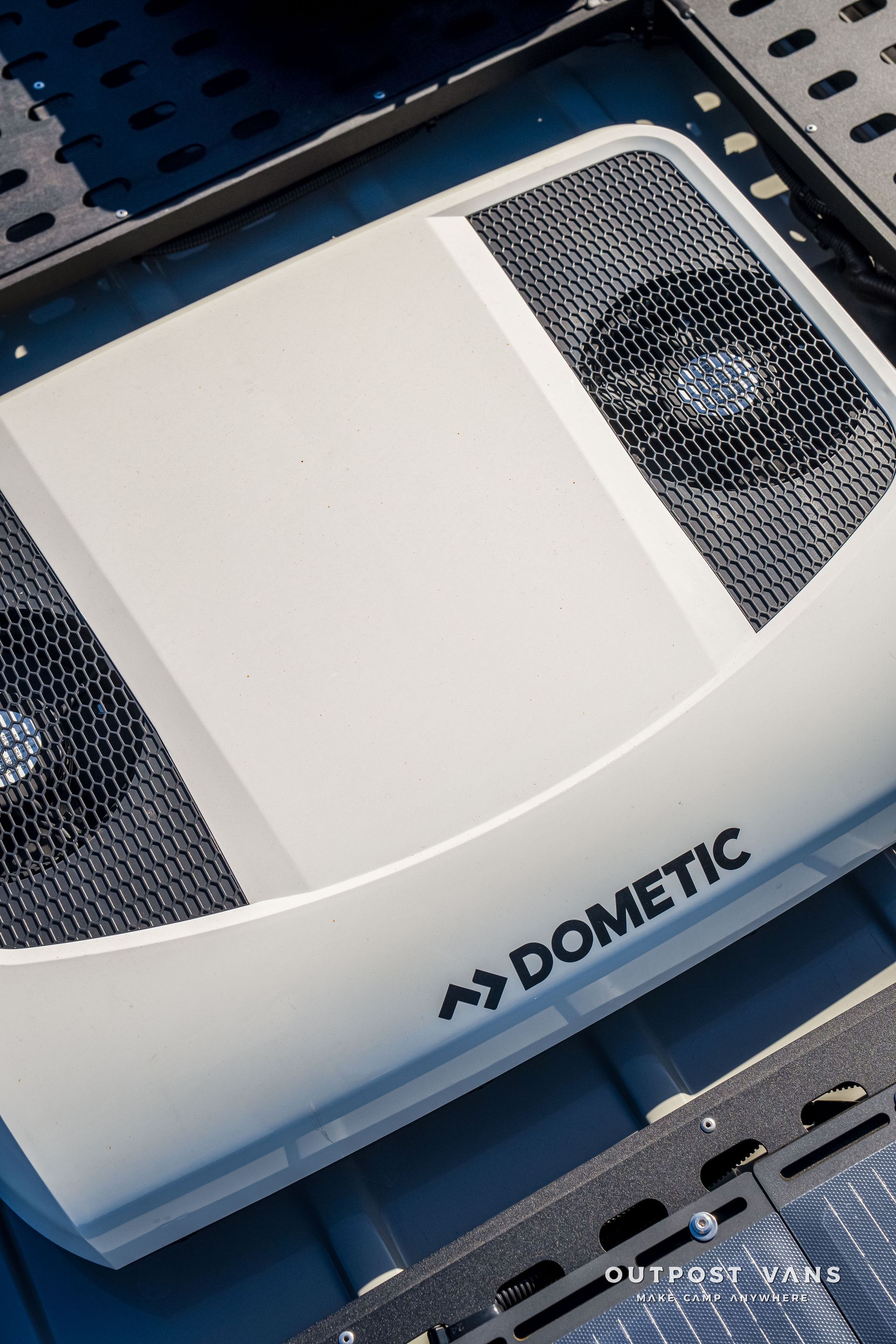 White Dometic air conditioner on a dark surface with vents.