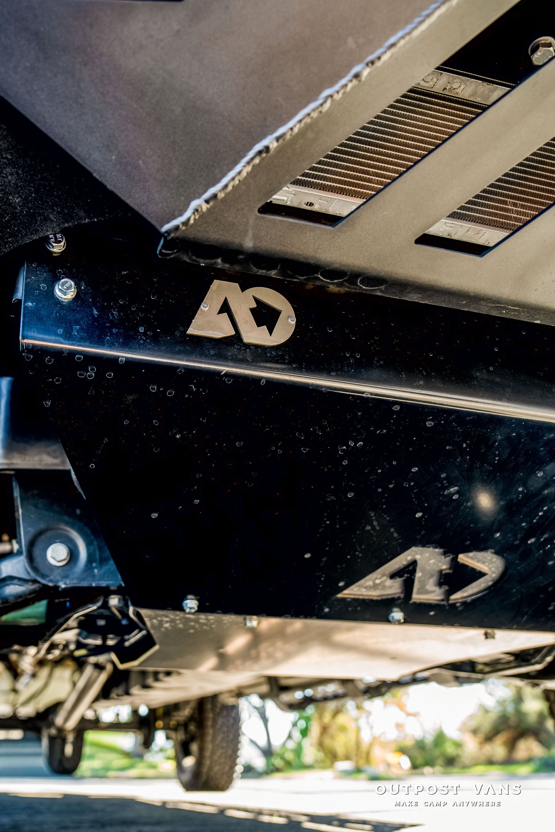 Black metal skid plates with “4D” logo, under a vehicle, protecting undercarriage.