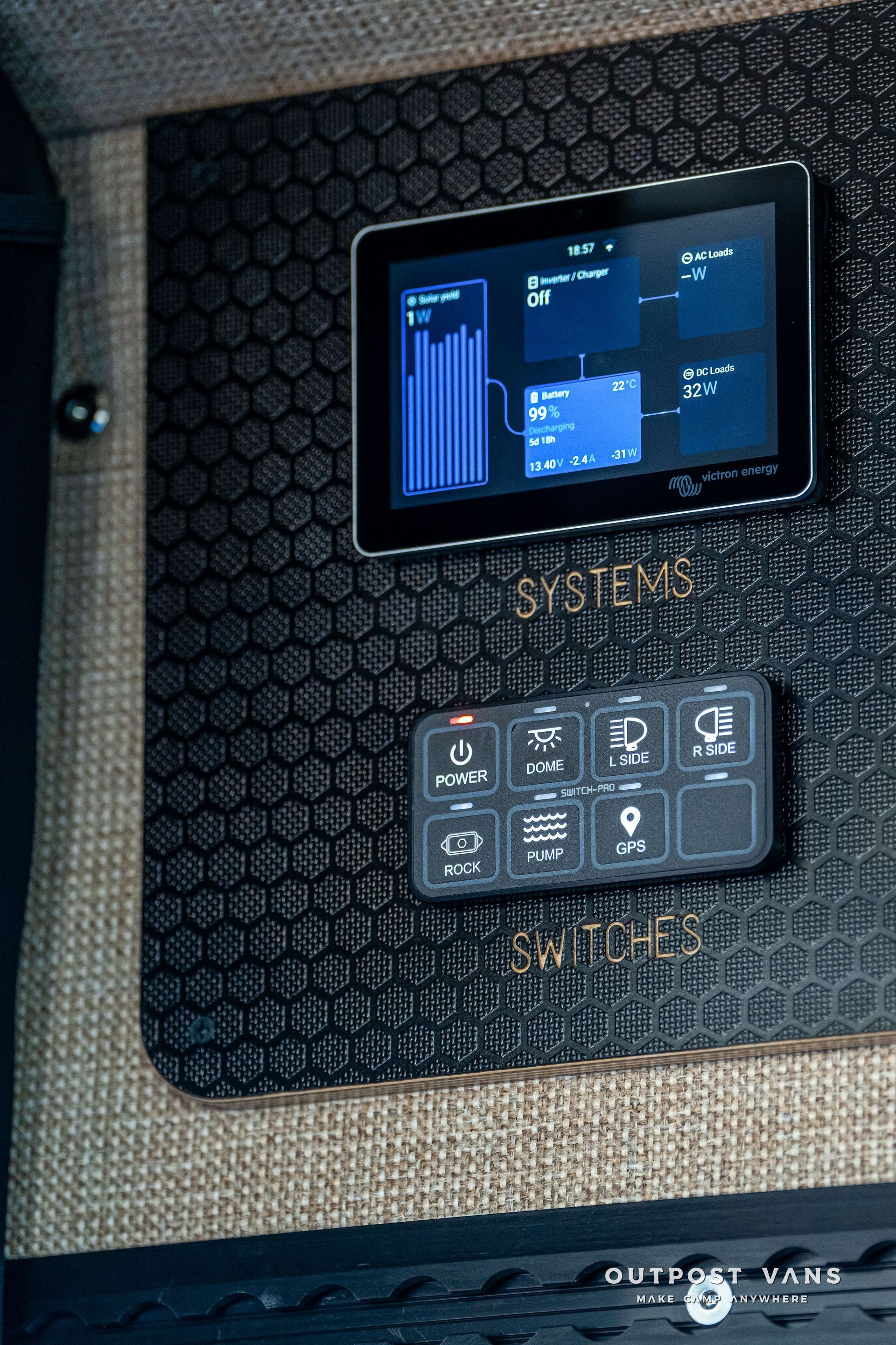 Control panel in a van: digital display showing systems info above a switch panel