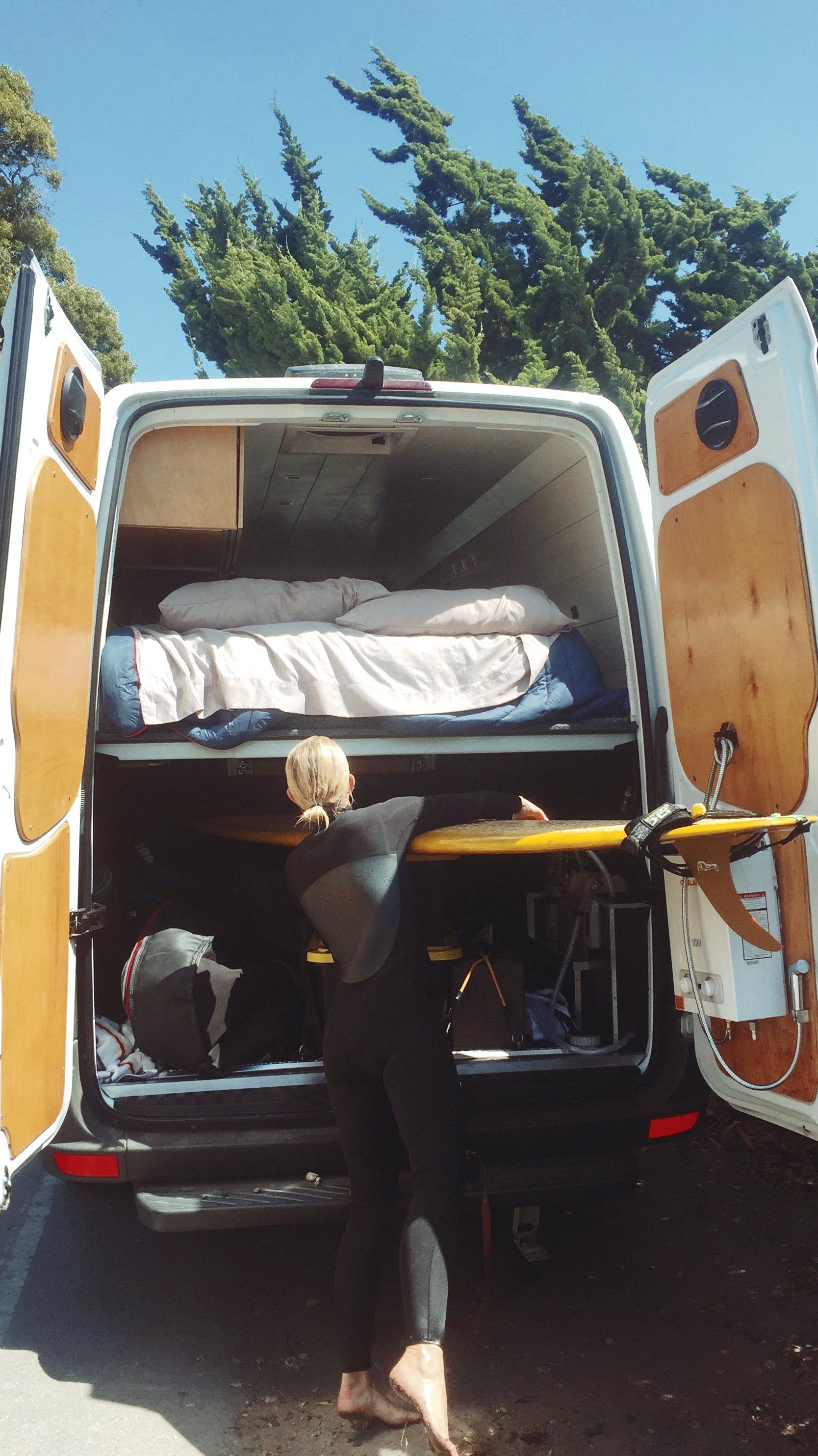 a person is standing in the back of a van with the door open