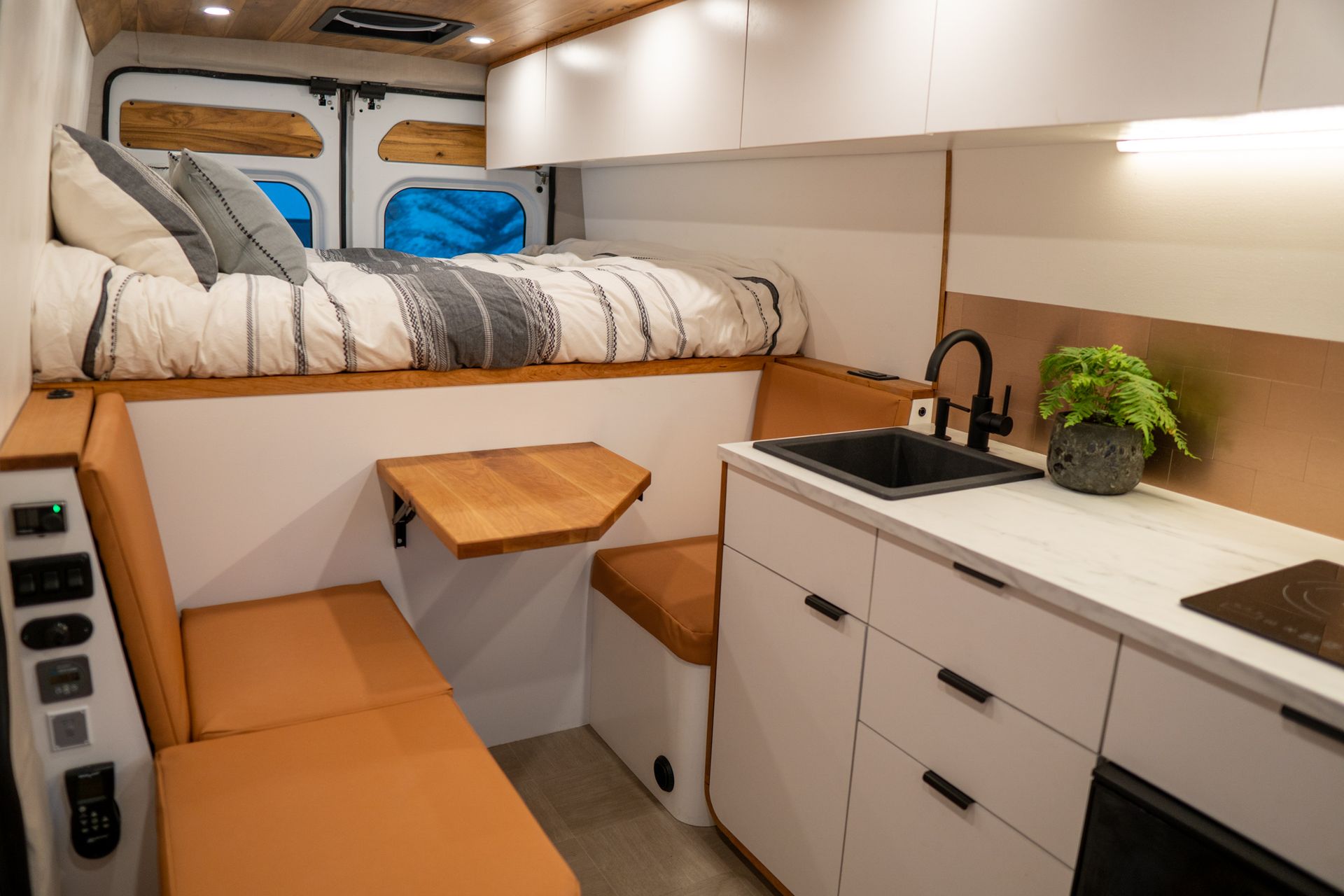 A van with a bed and a kitchen in it.