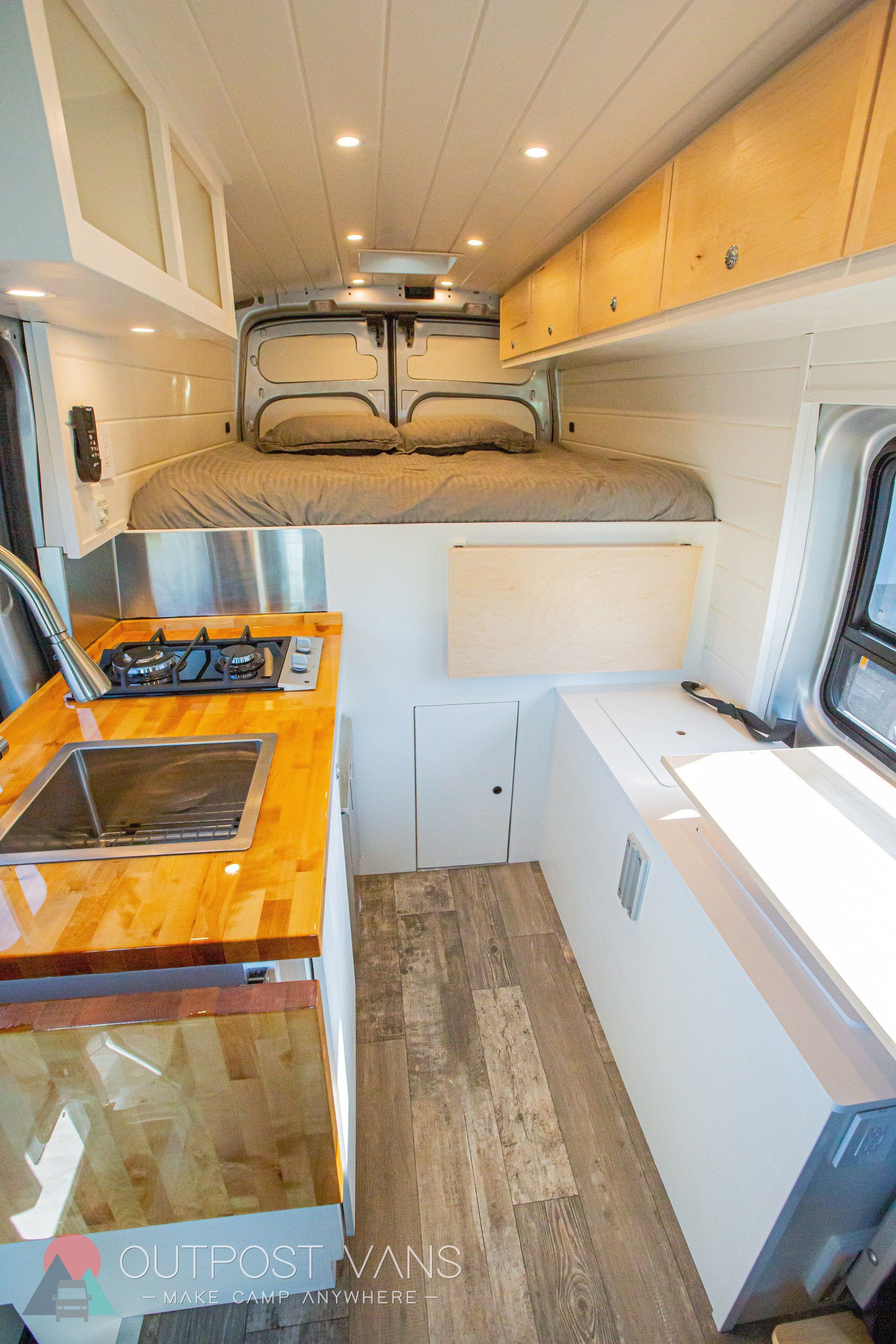 the inside of a van with a bed and a kitchen .