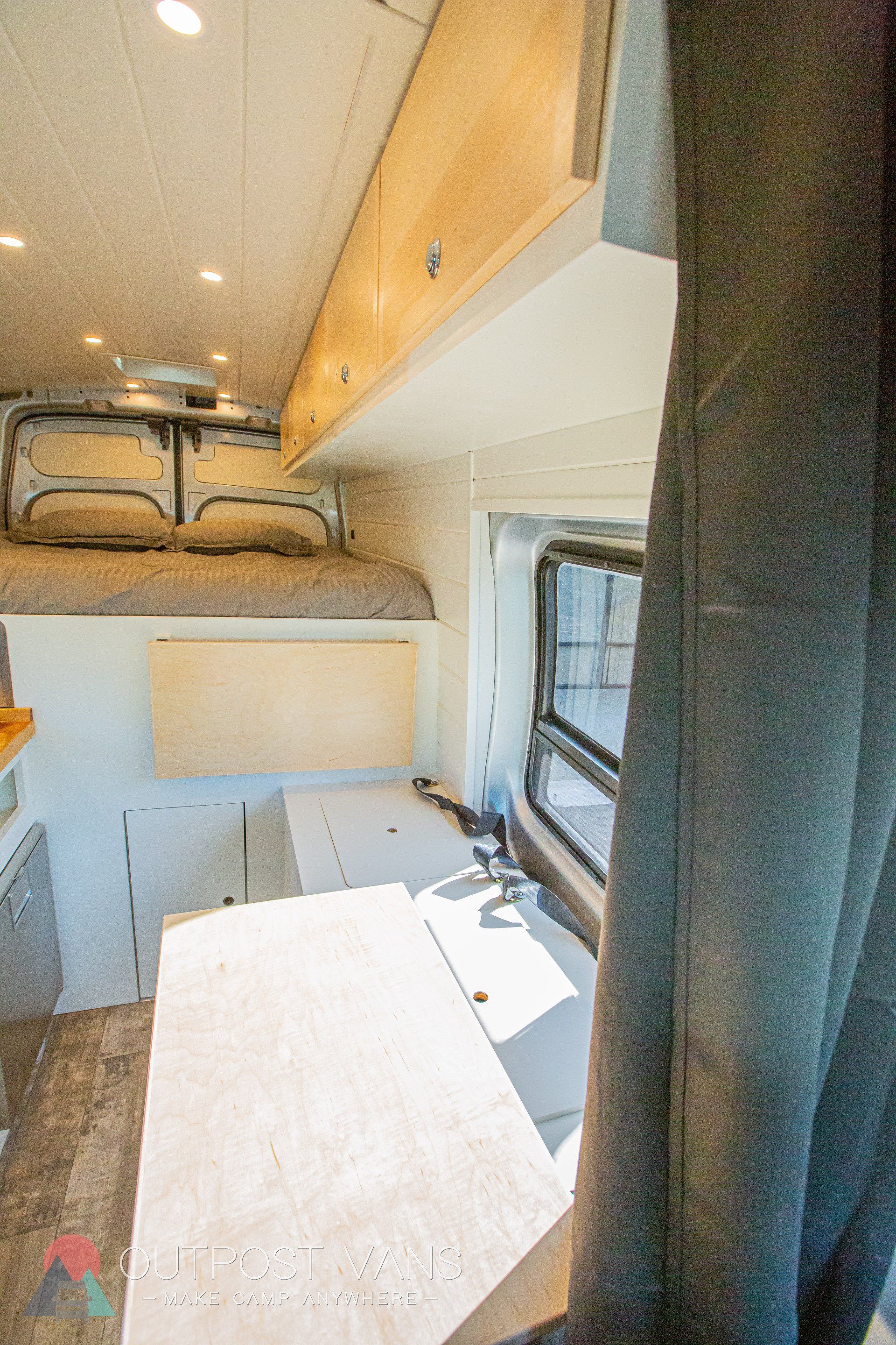 the inside of a camper van with a bed and a kitchen .