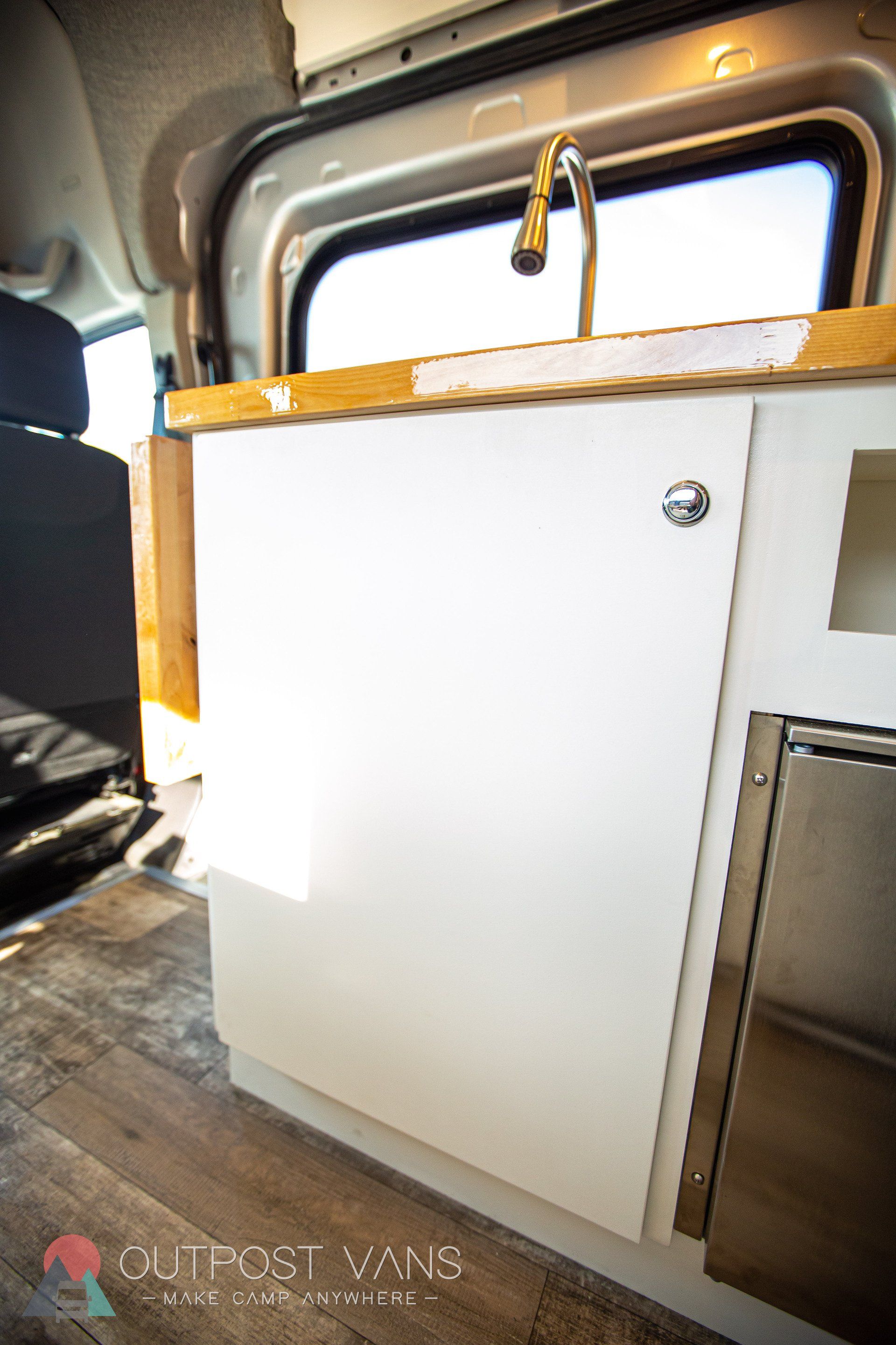 a white cabinet with a sink in a van .