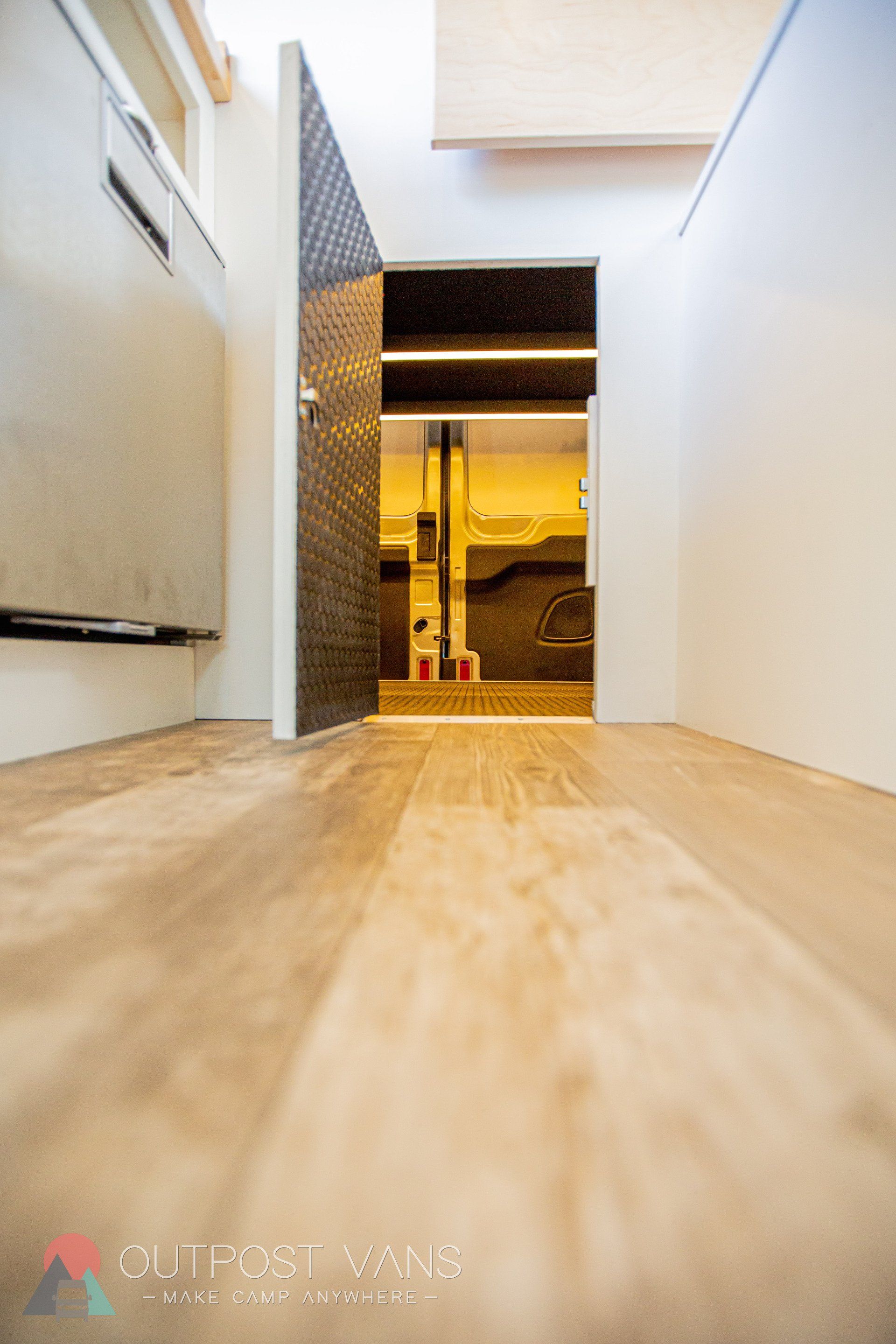 a hallway with a wooden floor and a door leading to a room .