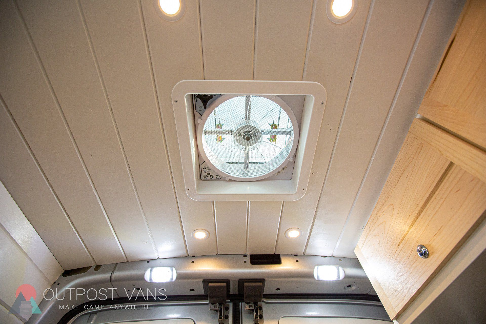 the ceiling of a van with a fan and lights on it .