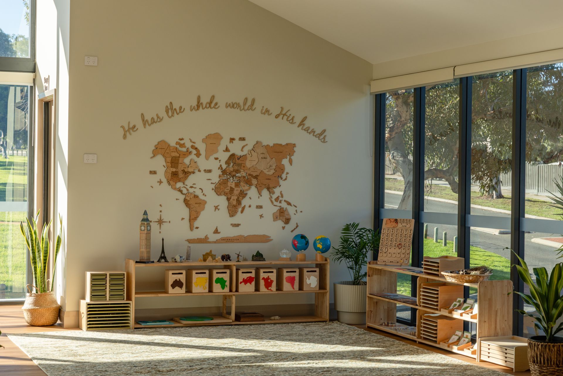 A woman and a child sitting on the floor, engaging with wooden blocks using the Montessori method.