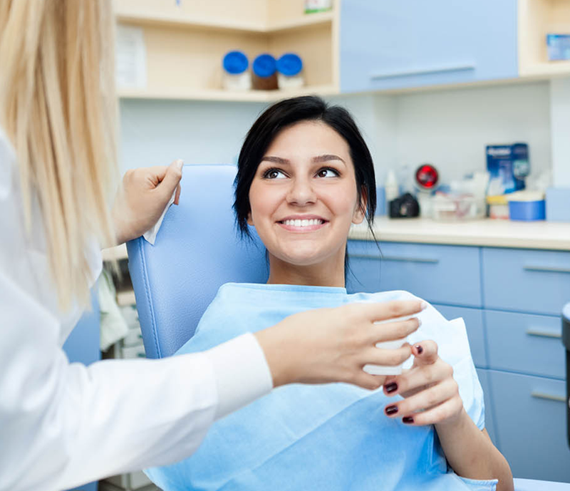 Dentist explaining dental benefits to patient in chair