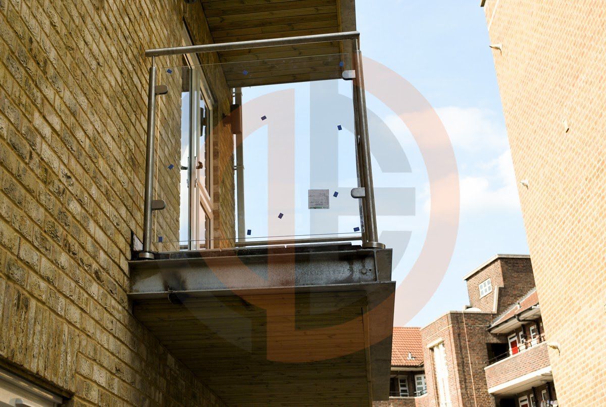 Ground floor view of upper balcony railings with glass panels