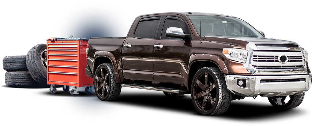 Brown pickup truck with a red toolbox and tires.