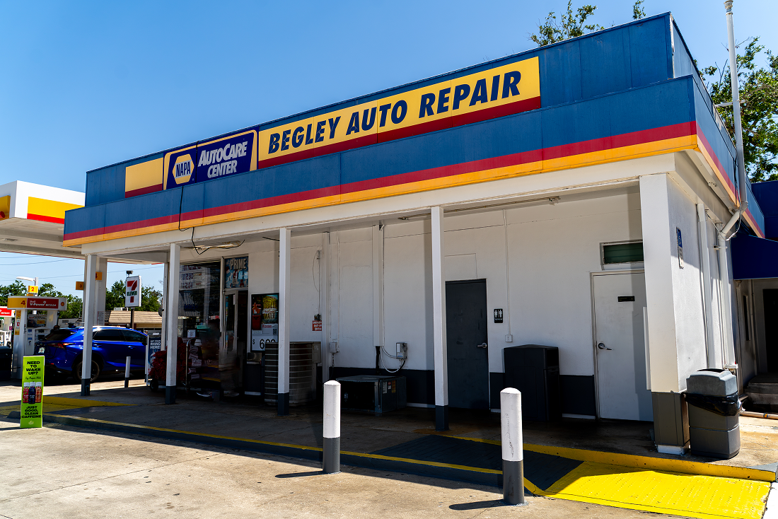 Begley Auto Repair building with blue and yellow awning; located at a gas station.