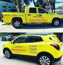 Yellow truck and SUV with Begley Auto Repair logos.