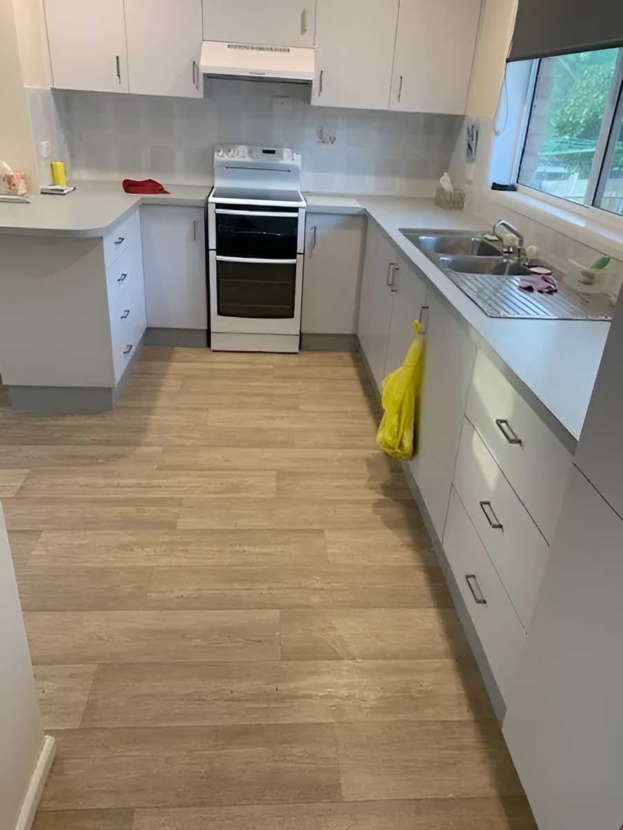 A Kitchen With White Cabinets, A Stove With Vinyl Flooring — Flooring Direct Mid North Coast in South Kempsey, NSW