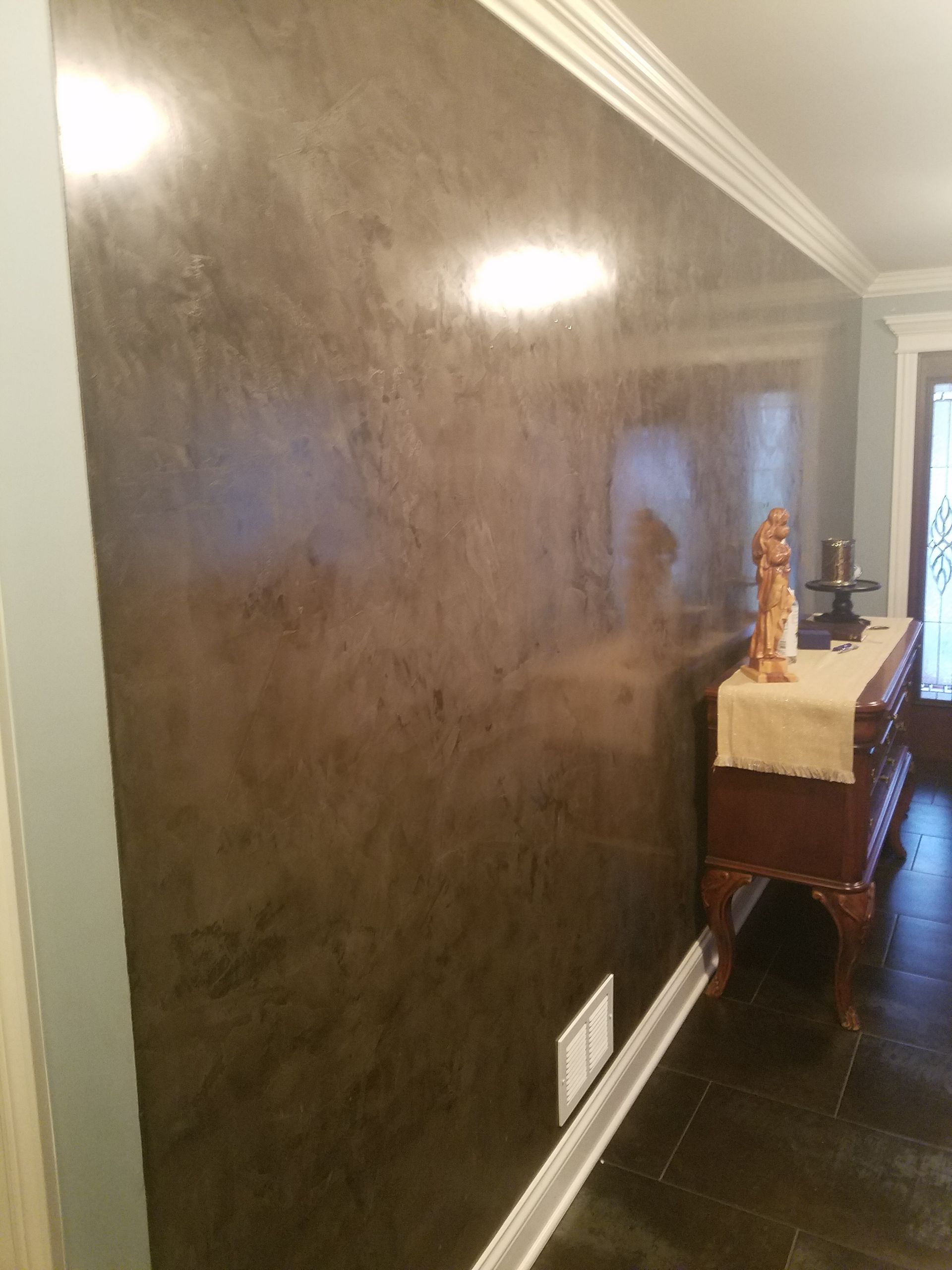 A wall with a statue on top of it in a room.