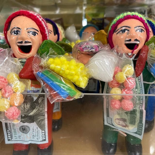 Candy dolls wearing hats, holding candy bags, with fake money attached.