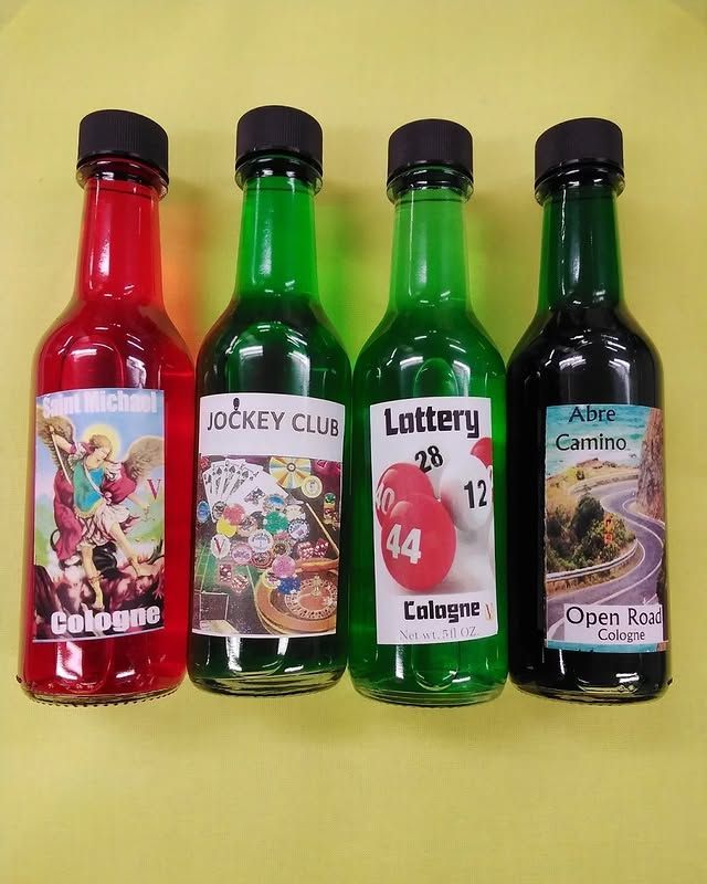 Four bottles of colored cologne with labels, red, green, and black, against a yellow background.