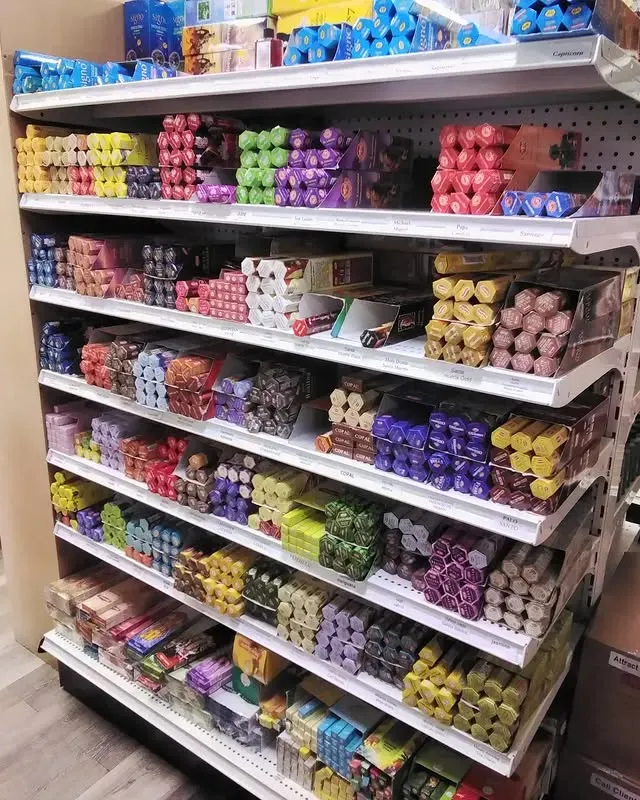 Shelves stocked with colorful candy, arranged in rows. A variety of shapes and sizes. Store setting.
