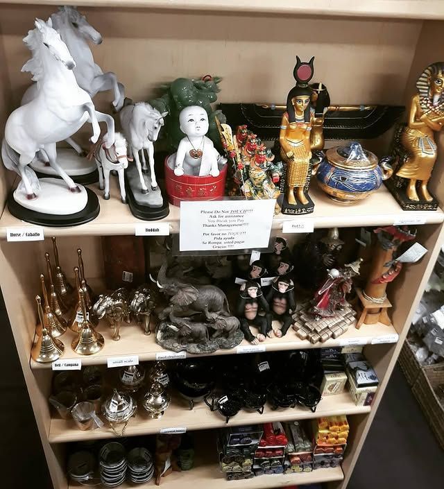 Shelf display of assorted figurines: horses, baby, Egyptian statues, elephants, and other decorative items.