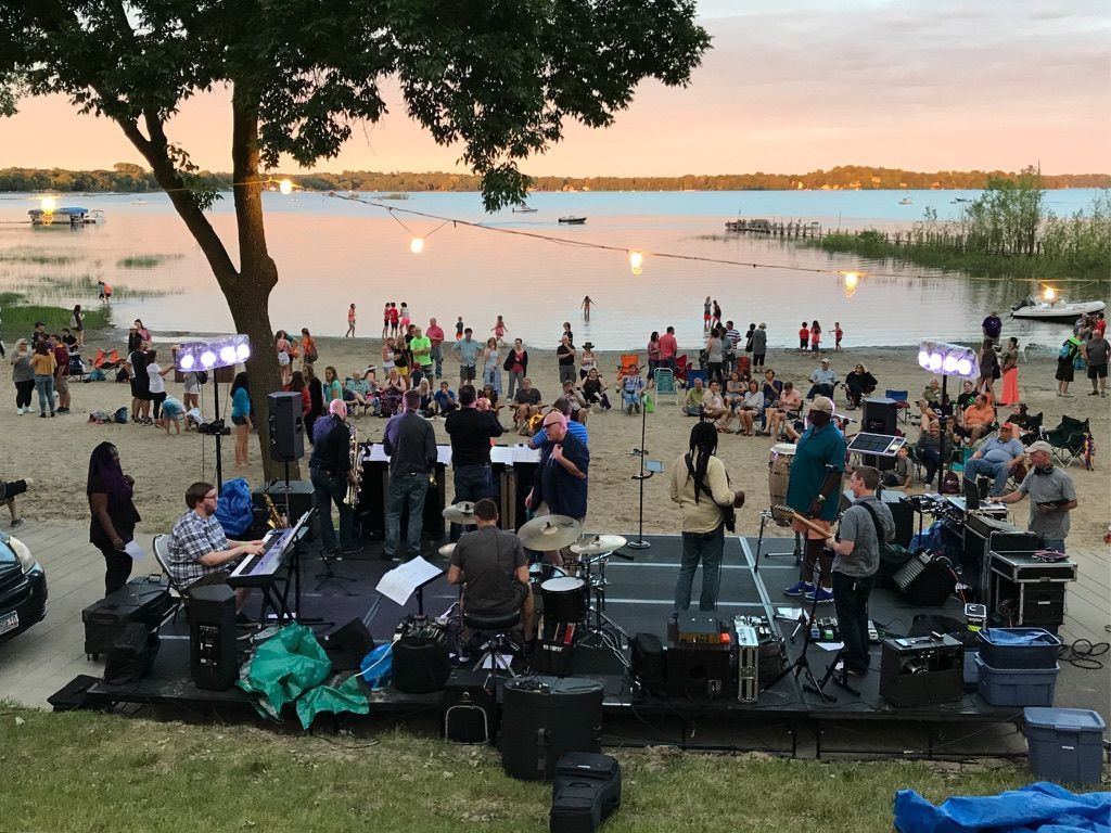 People gathering at White Bear Lake for the beach dance at sunset.