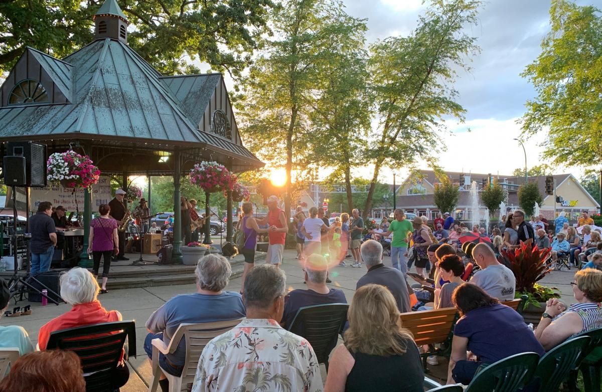 Crowd listening to a live band and some couples dancing at sunset in White Bear Lake Marketfest