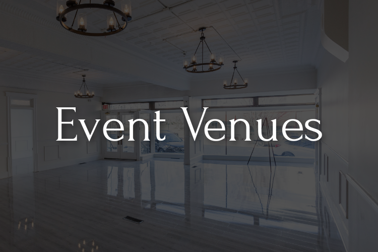 Bright, empty event venue with chandeliers and large windows. 