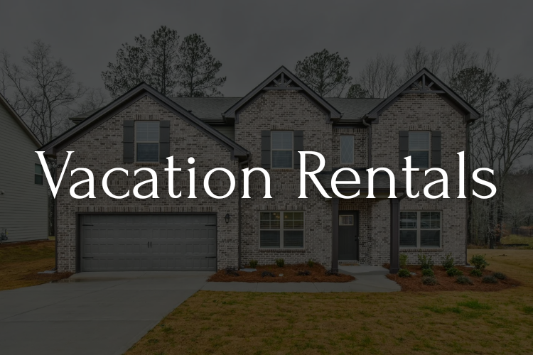 Vacation Rentals text overlayed on a brick home with a gray garage door.