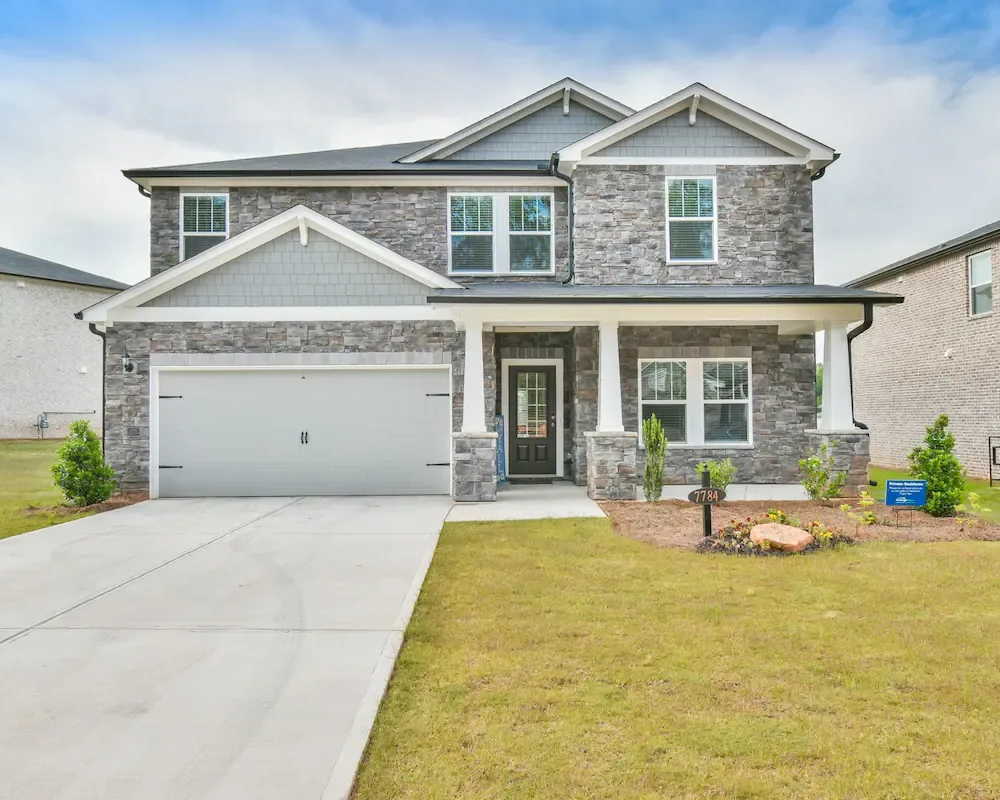 Buildings with brick facades and storefronts, cars parked in front.