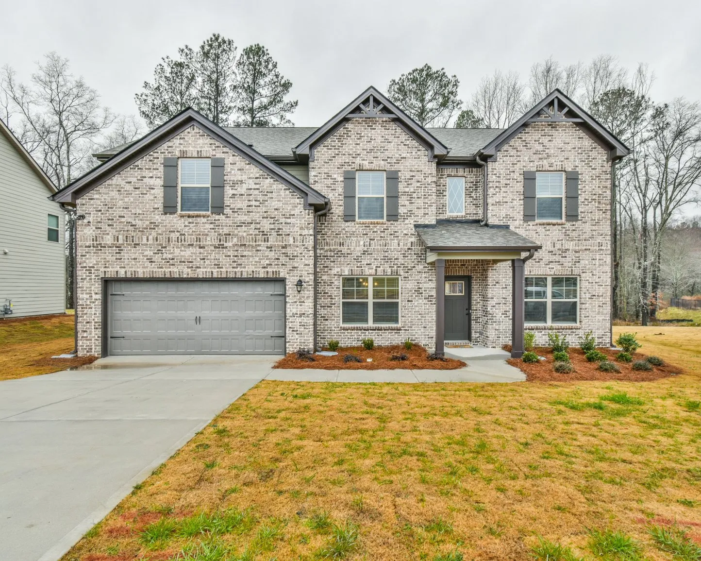 Buildings with brick facades and storefronts, cars parked in front.