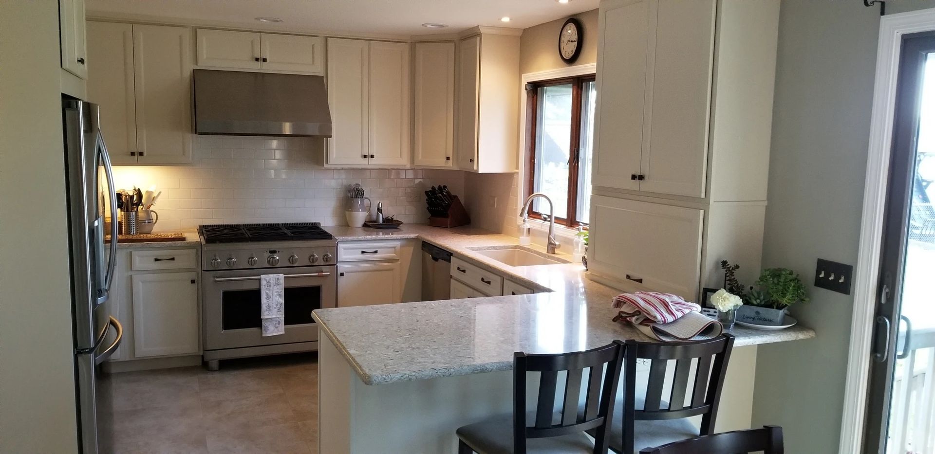 Kitchen with white cabinets, stainless steel appliances, and a granite countertop island.