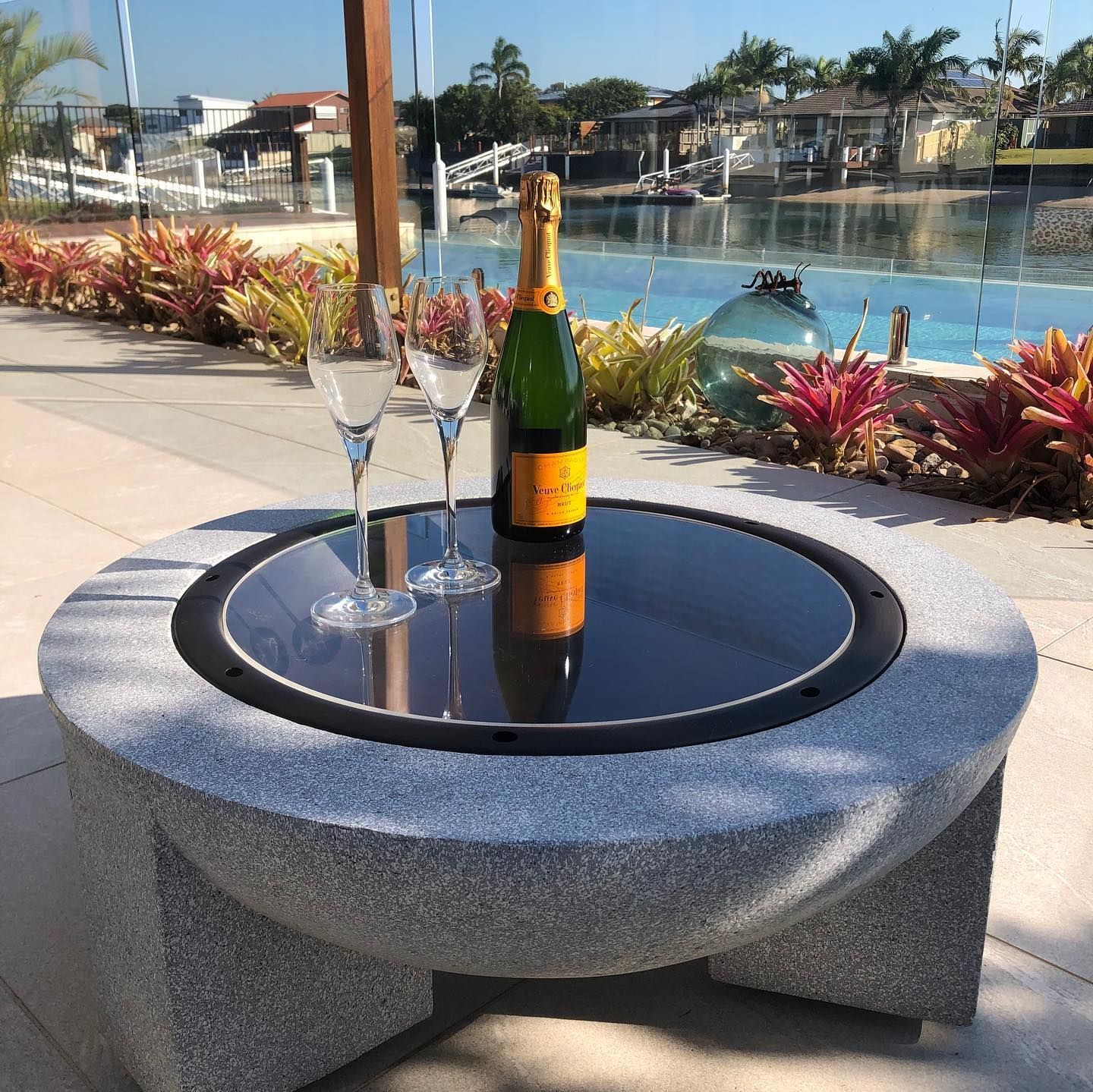 A Bottle of Champagne Sits on a Table Next to Two Wine Glasses — Bent Plastics in Kunda Park, QLD