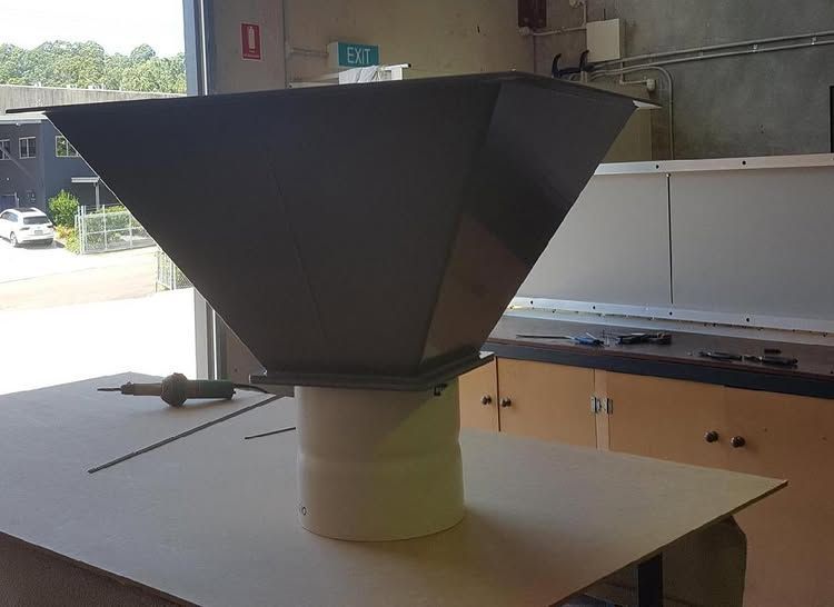 A Large Metal Cone is Sitting on Top of a Cardboard Box in a Kitchen — Bent Plastics in Kunda Park, QLD