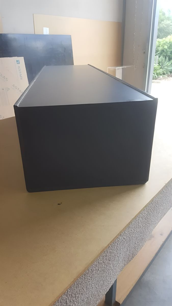 A Black Box Is Sitting On Top Of A Wooden Table — Bent Plastics in Noosa, QLD