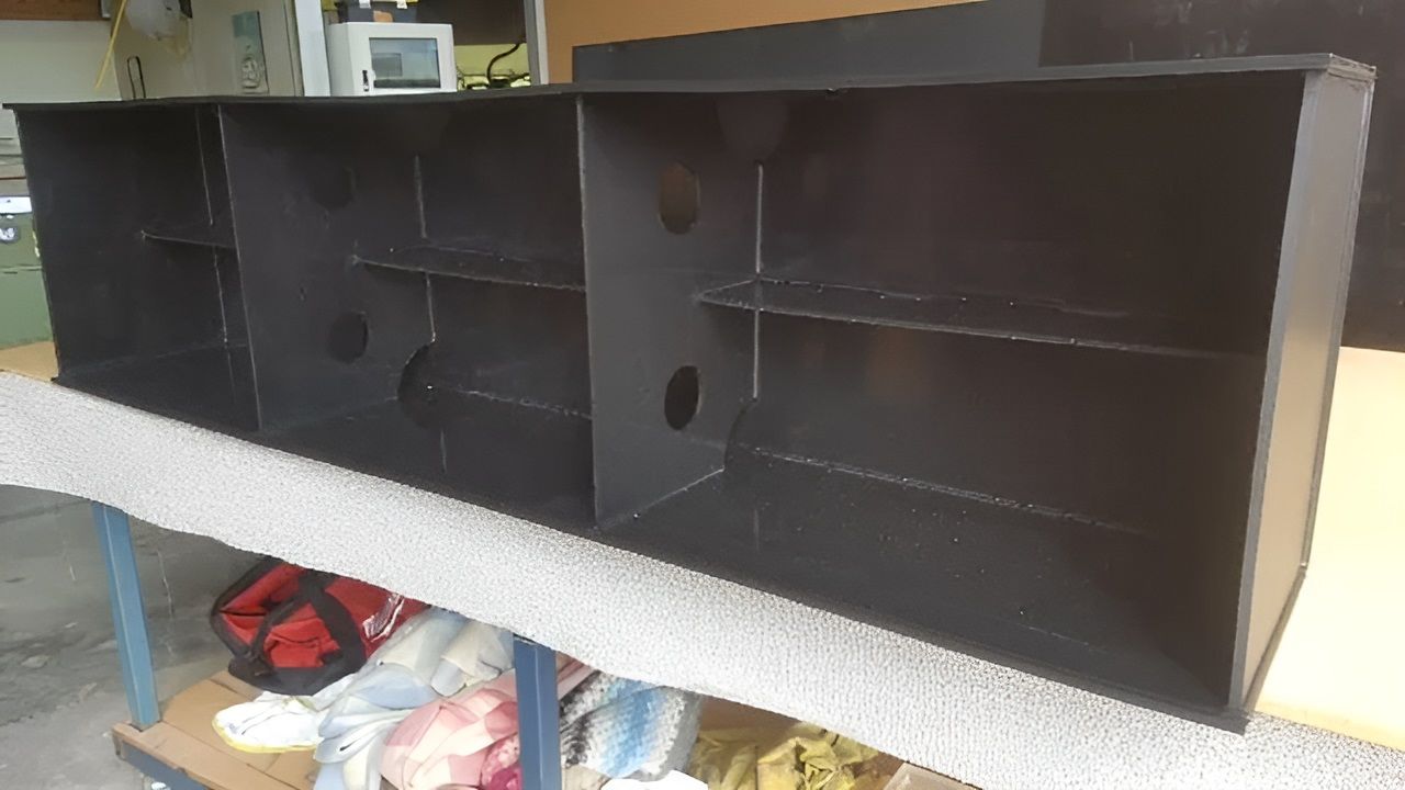 A Long Black Shelf Is Sitting On Top Of A Table — Bent Plastics in Noosa, QLD