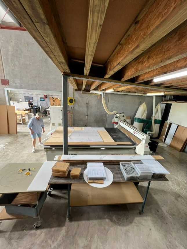 A Man is Standing in a Room With a Table and a Machine — Bent Plastics in Kunda Park, QLD