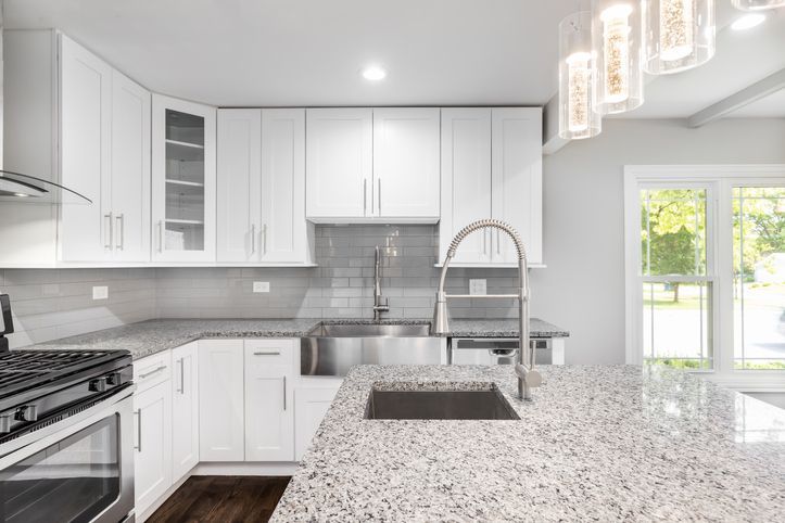 A white kitchen with a stainless steel apron sink