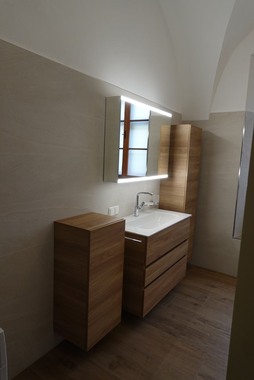 Ein Badezimmer mit Waschbecken, Spiegel und Schränken